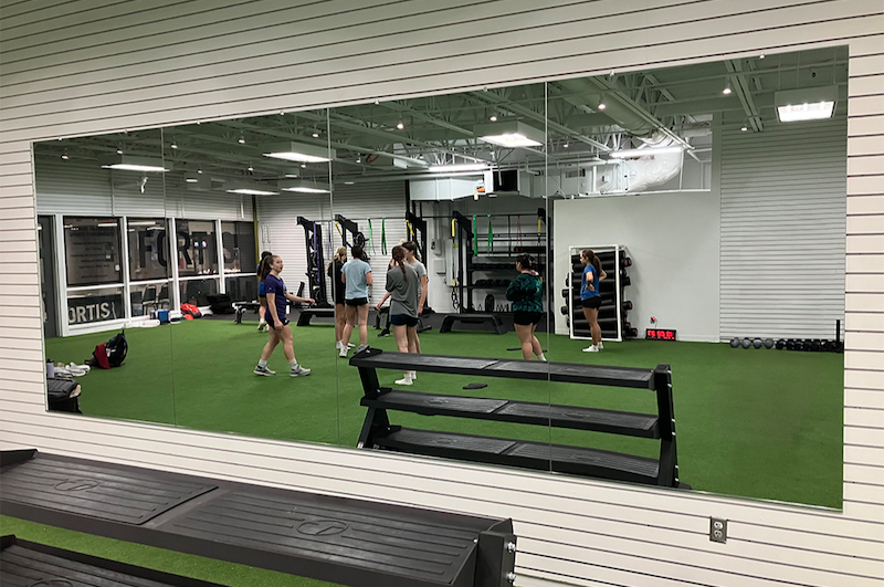 Frameless gym mirror wall in a fitness studio